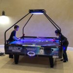 Galaxy Quad Four Player Air Hockey Table with two players at an event.