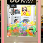 Custom branded claw machine with 4 inch balls at rental event San Jose
